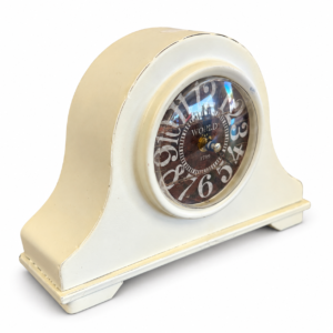 Vintage-style cream mantel clock with a distressed finish and decorative Roman numeral-inspired clock face.