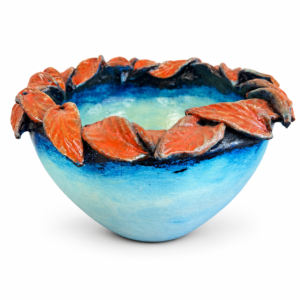 Decorative blue bowl with sculpted orange leaves around the rim and a glossy artistic finish.