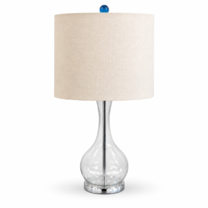 Clear glass table lamp with a teardrop-shaped base, chrome accents, cream fabric drum shade, and blue finial.