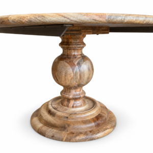 Close-up of an ornate turned wood pedestal base with rich natural grain supporting a round dining table.