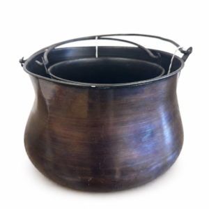 Rustic dark bronze metal cauldron planter with rounded body and metal carrying handle.