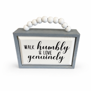 Farmhouse wood sign with gray frame, white beaded handle, and “Walk Humbly & Love Genuinely” inspirational message.