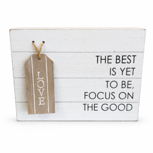 White rustic wood sign reading “The Best Is Yet to Be, Focus on the Good” with a hanging wooden Love tag.