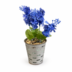 Decorative blue floral arrangement with green leaves and natural stones in a distressed metal planter.